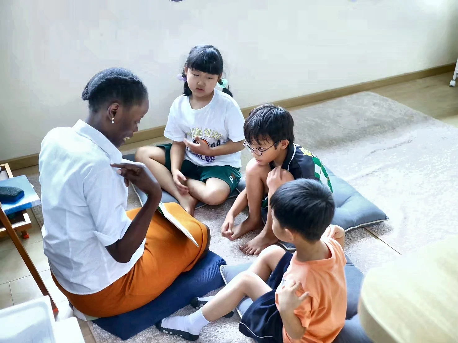 A teacher reading with students in a circle